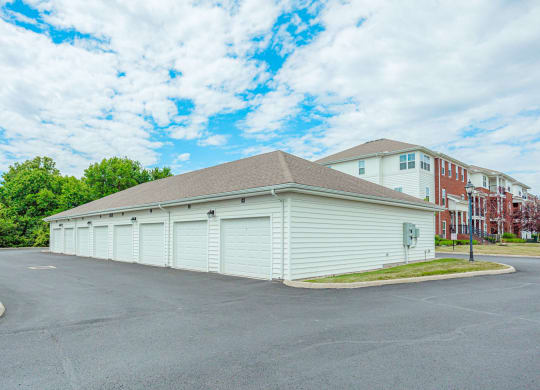 a garage with white doors and a building in the background