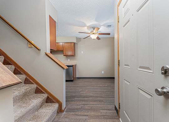 A hallway with a staircase and a door