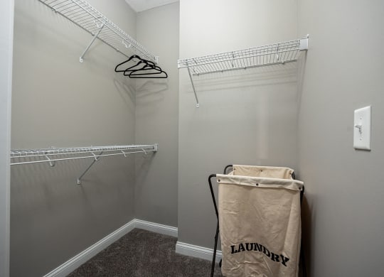 a walk in closet with a bag on the floor and two shelves on the wall