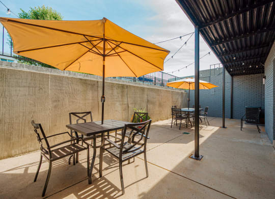 a patio with tables and chairs under umbrellas