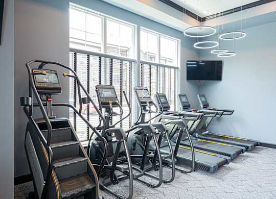 A gym with treadmills, elliptical machines, and a stair climber.