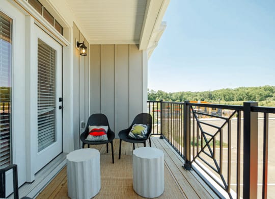 a balcony with two chairs and a view of a river
