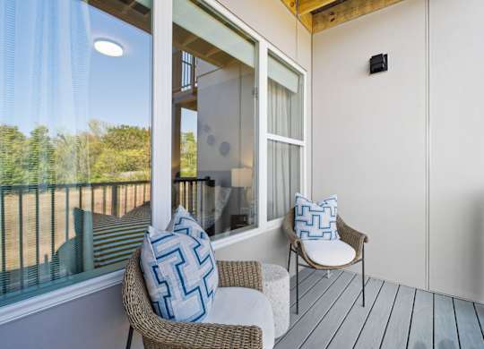 A balcony with a chair and a pillow.