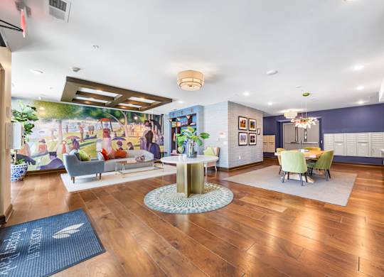 A living room with a wooden floor and a large mural on the wall.
