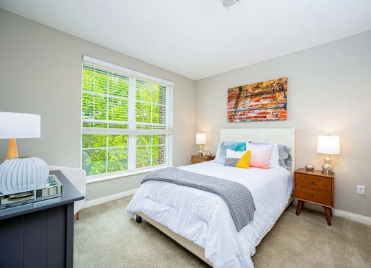 a bedroom with a bed and two windows
