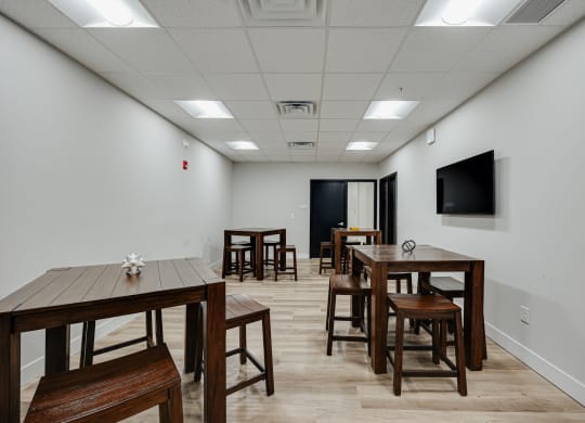 a dining room with tables and chairs and a tv