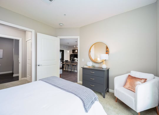 a bedroom with a white bed and a white chair
