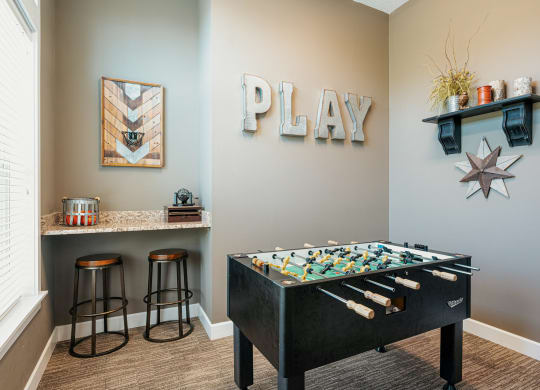 a game room with a foosball table and a play area