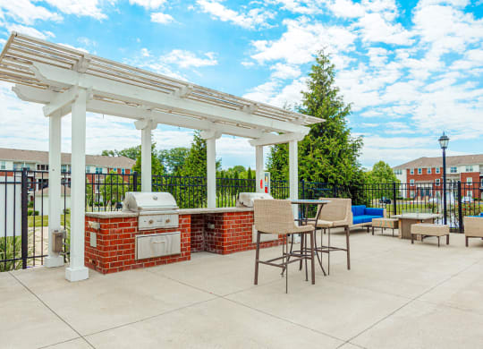 a patio with a barbecue grill and a pergola