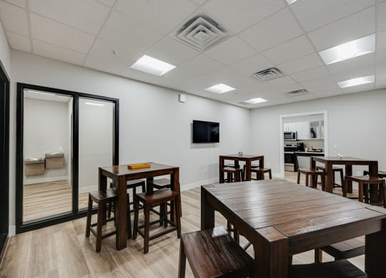 a dining room with tables and chairs and a tv on the wall