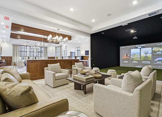 A living room with a brown couch and a chandelier.