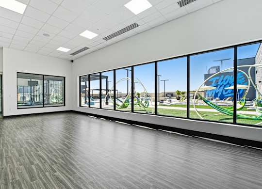 A spacious room with a view of a playground through the windows.