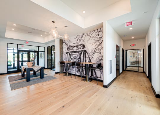 a living room with a chair and a table and a wall mural
