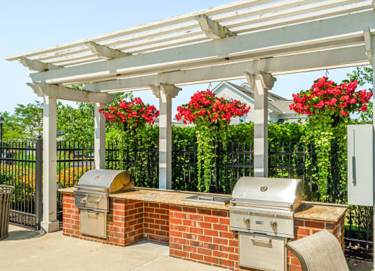 a patio with a barbecue grill and a pergola