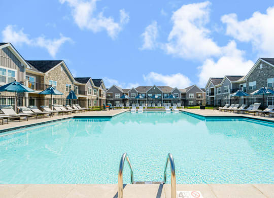 a large swimming pool with apartments in the background