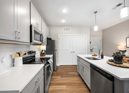 A modern kitchen with white cabinets and stainless steel appliances.