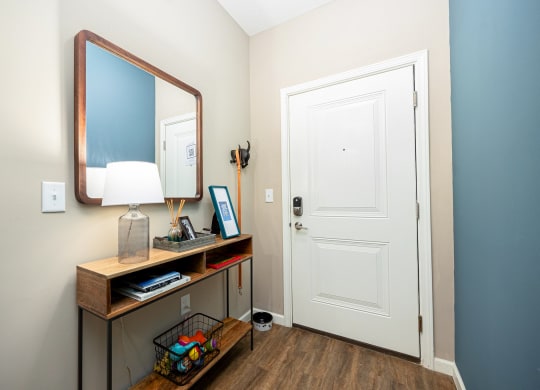 a hallway with a mirror and a desk with a door