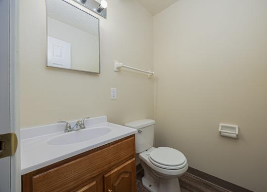A white sink with a mirror above it and a toilet in a bathroom.