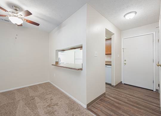 a bedroom with a ceiling fan and a door to a bathroom