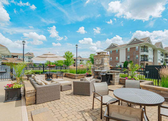an outdoor patio with tables and chairs and a building in the background