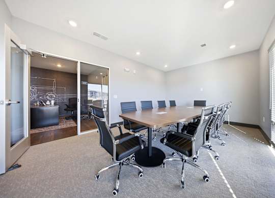 A conference room with a table and chairs.