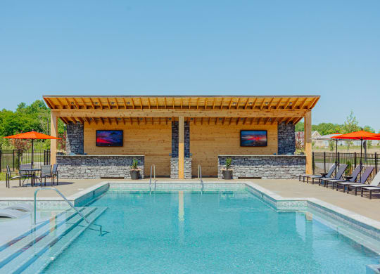 a swimming pool with a pergola next to a resort style pool