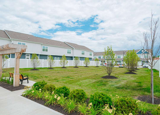 a park with a lawn and benches in front of a building