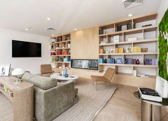 A living room with a grey couch, a white table, and a green plant.