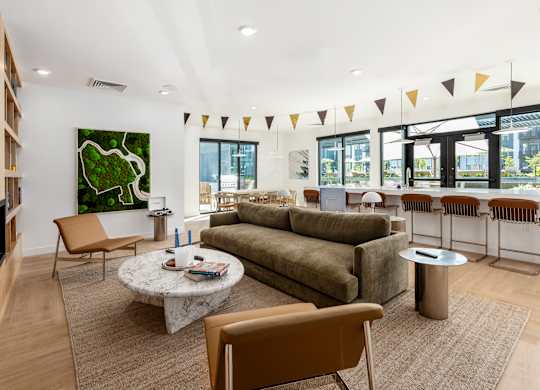 A living room with a green painting on the wall and a large sectional sofa.