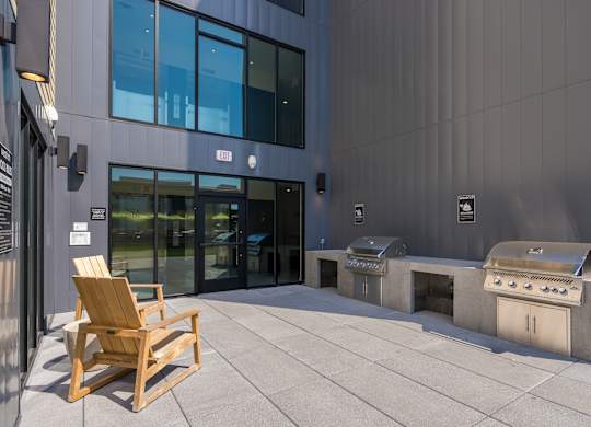 A wooden chair is placed on a patio in front of a building.