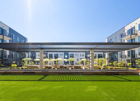 A modern building with a green lawn in front.