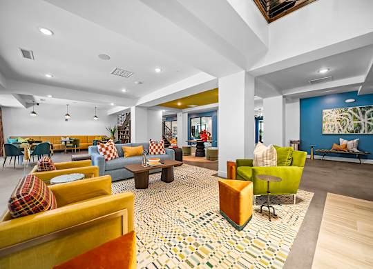 A spacious living room with a patterned rug and a variety of seating options.
