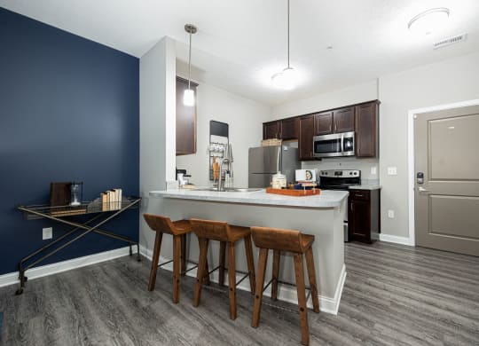 a kitchen with a large island with three stools