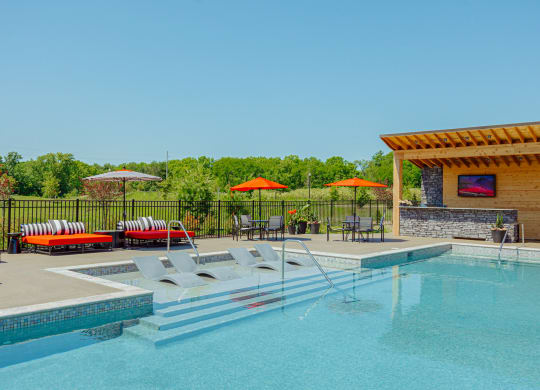 a swimming pool with chairs and umbrellas next to a resort style pool