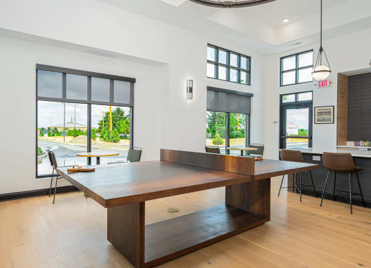 a dining room with a large table and chairs and windows