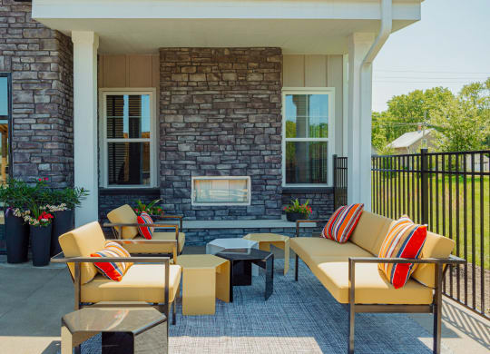 a patio with furniture and a fireplace on the side of a house