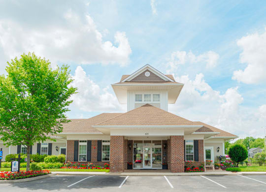 the exterior of a building with a parking lot and trees