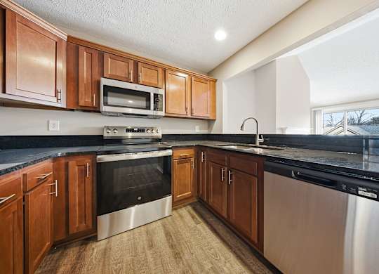 A kitchen with wooden cabinets and stainless steel appliances.