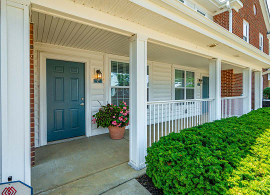 the front porch of a house with a blue door