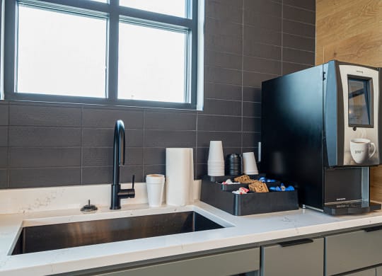 a kitchen with a sink and a coffee maker