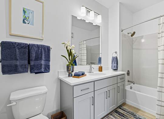 A white bathroom with a white toilet, white sink, and a white bathtub.