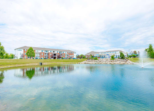 a pond with a fountain in front of a building