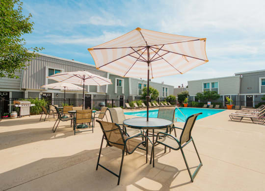 our apartments have a pool and patio with chairs and umbrellas