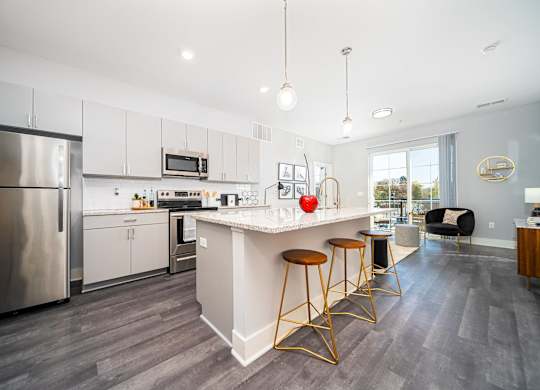 a kitchen with a large island with three stools
