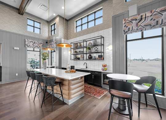 A modern kitchen with a large island and a dining table set up.