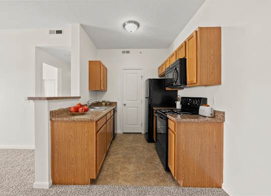 A kitchen with black appliances and wooden cabinets.