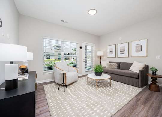 A living room with a grey couch, a white chair, and a coffee table.