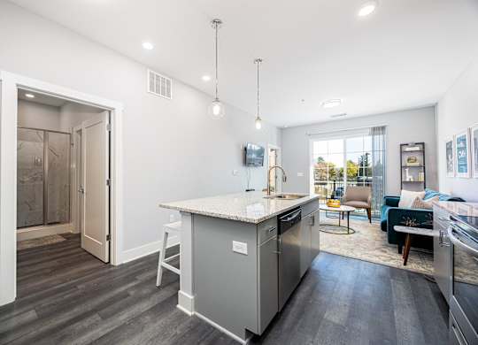 a kitchen with an island and a living room with a sliding glass door