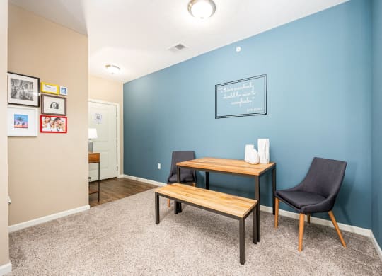 a home office with a blue wall and a desk with a chair and a table
