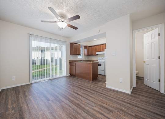 A room with a ceiling fan and wooden flooring.